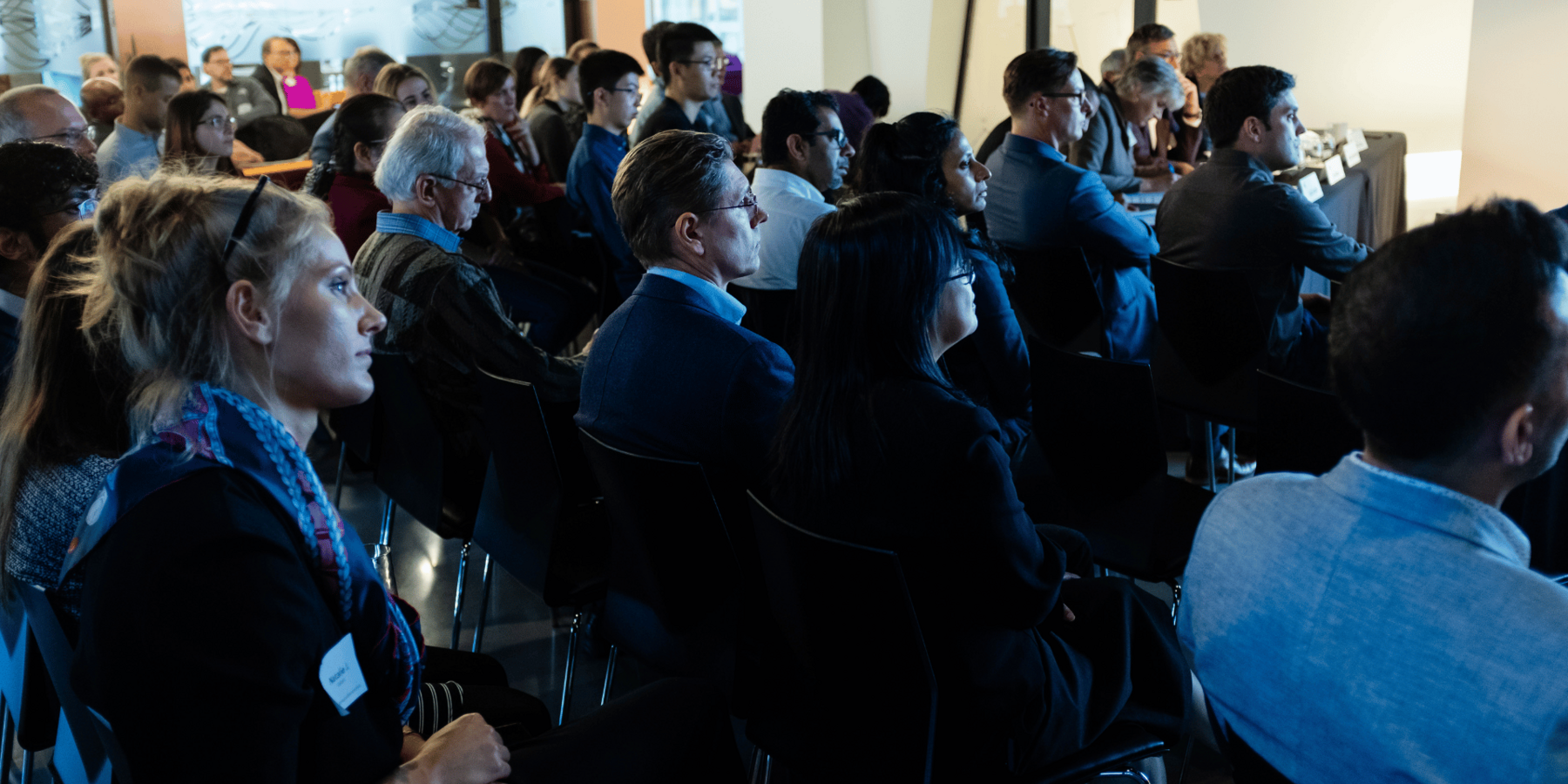 a group of people listen to a presentation