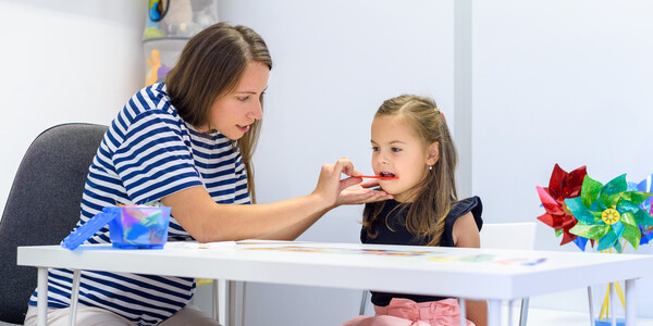 Therapist helps a child with pronunciation