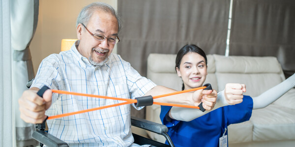 therapist shows someone how to use an exercise band