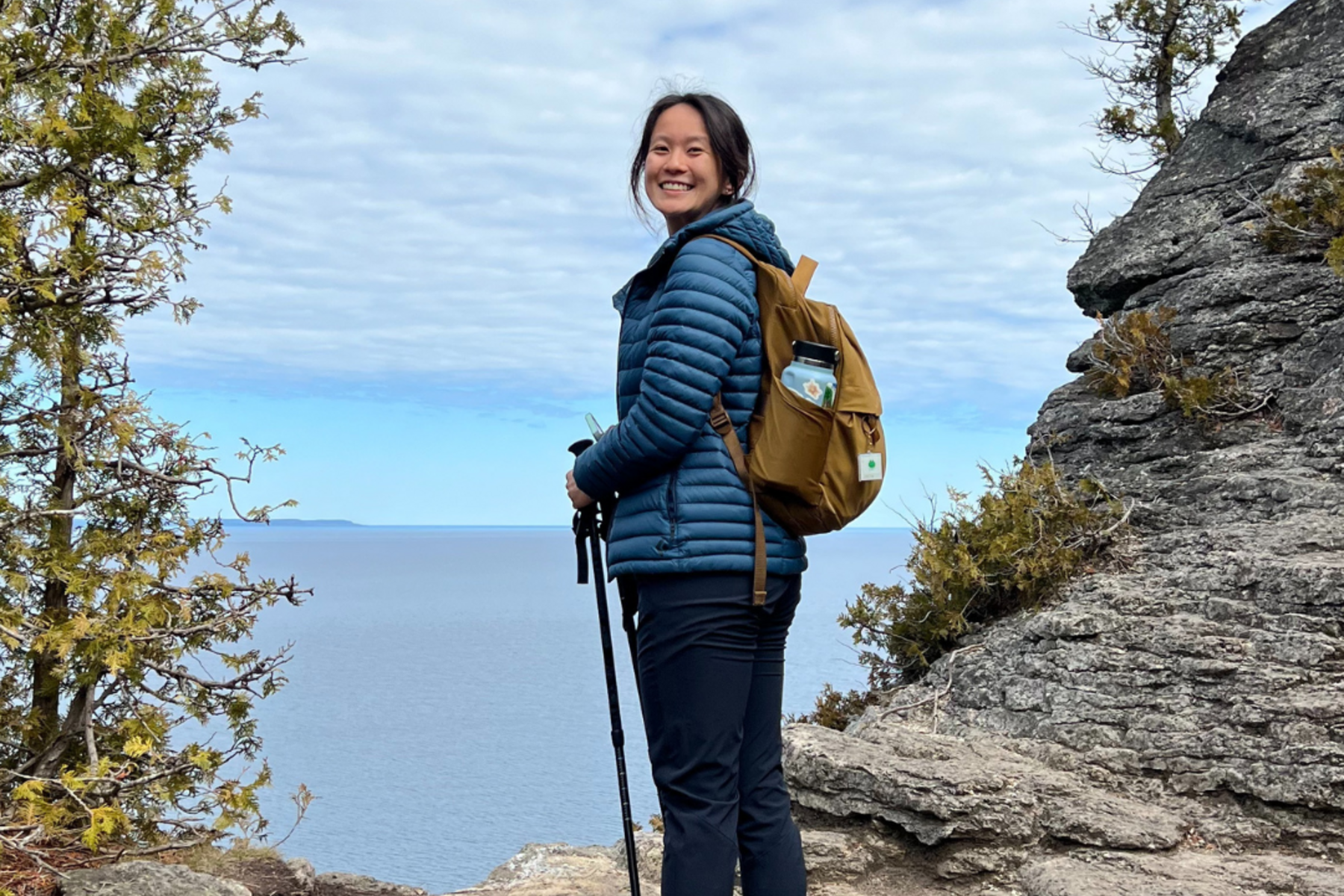 Samantha stands on the edge of cliff