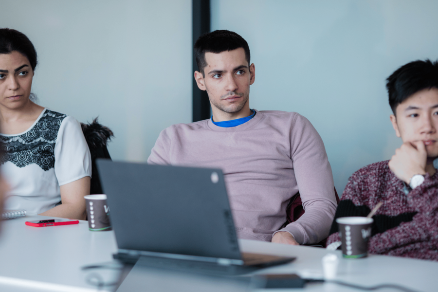 three people listening to a presentation