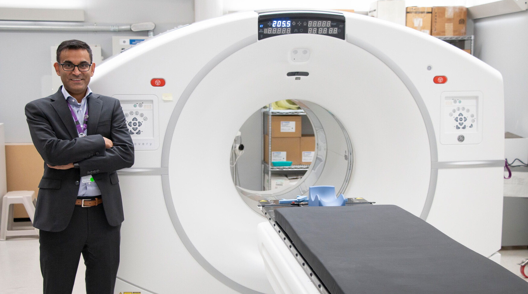 Neil Vasdev stands next to a CT machine.