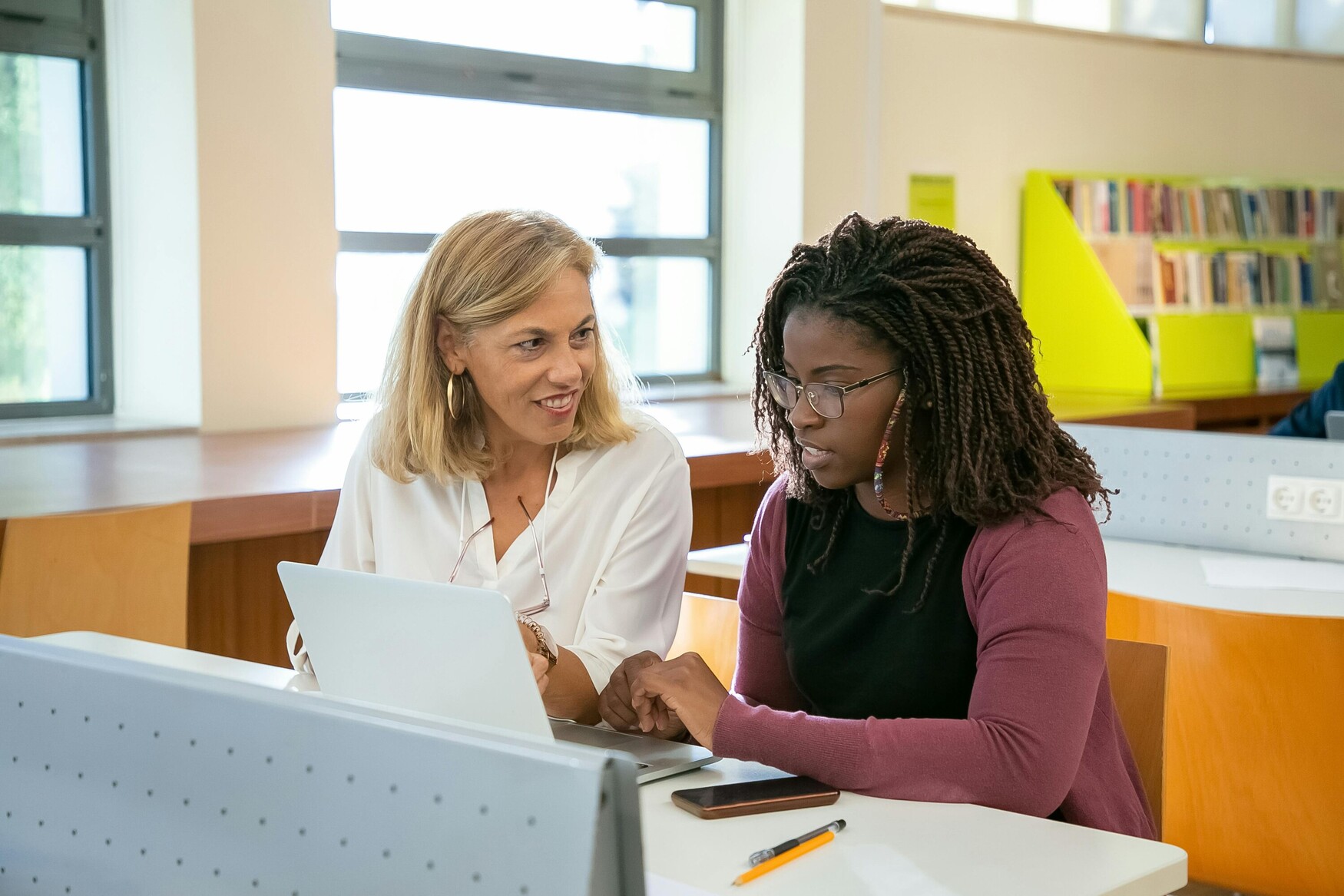 Two people working together in front of a laptop